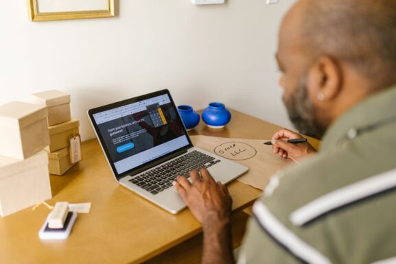 A small business owner using a laptop at a desk for business planning