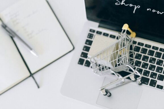 A miniature shopping cart on a laptop keyboard, representing the growth of online local marketplace shopping