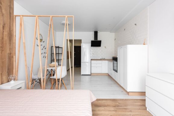 A spacious-feeling small studio apartment with an open kitchen and minimalist decor